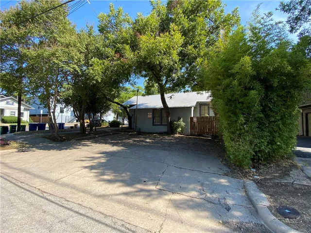 a view of a house with a tree next to a yard