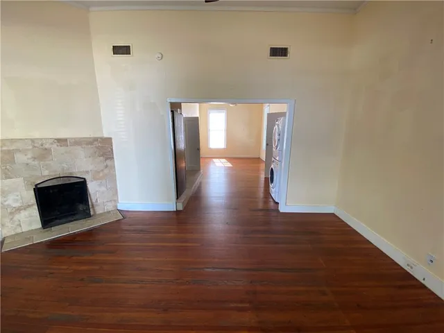 a view of empty room with wooden floor and fireplace