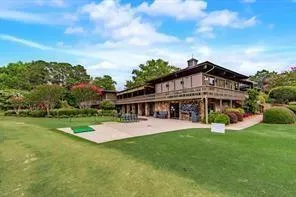 a view of a house with a big yard and large trees