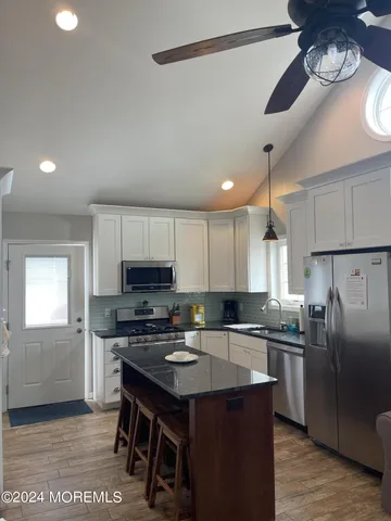 a kitchen with a sink a microwave a refrigerator and cabinets