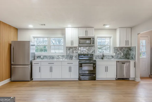 a kitchen with stainless steel appliances a refrigerator sink and stove