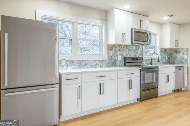 a kitchen with white cabinets and white appliances