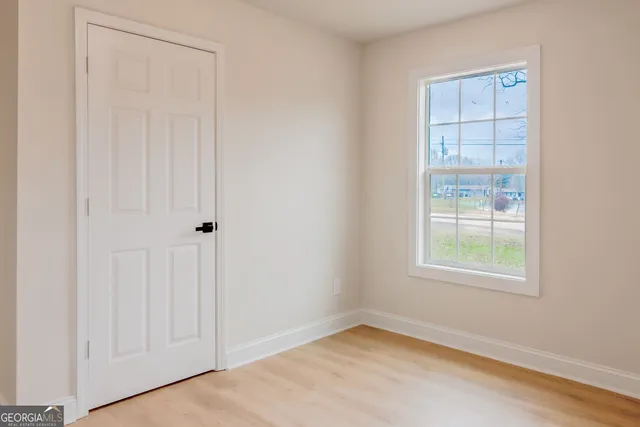 an empty room with windows and closet