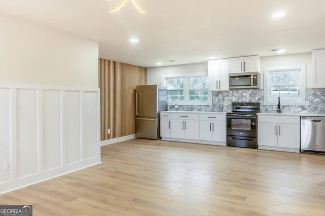 a kitchen with stainless steel appliances a refrigerator and a stove top oven
