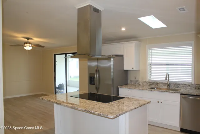 a kitchen with stainless steel appliances granite countertop a sink and a refrigerator
