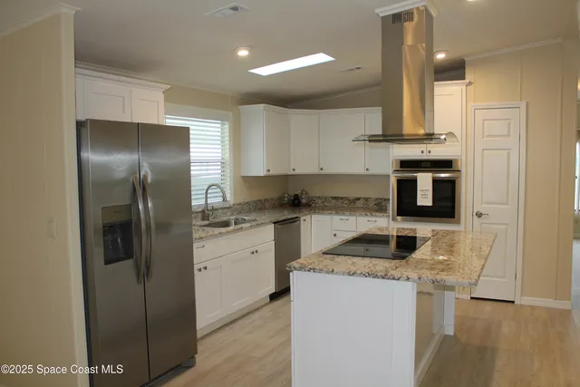 a kitchen with stainless steel appliances granite countertop a refrigerator and a stove top oven