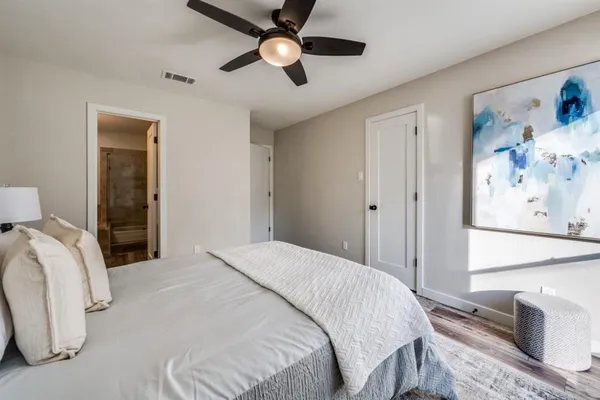 a bedroom with a large bed and a chandelier