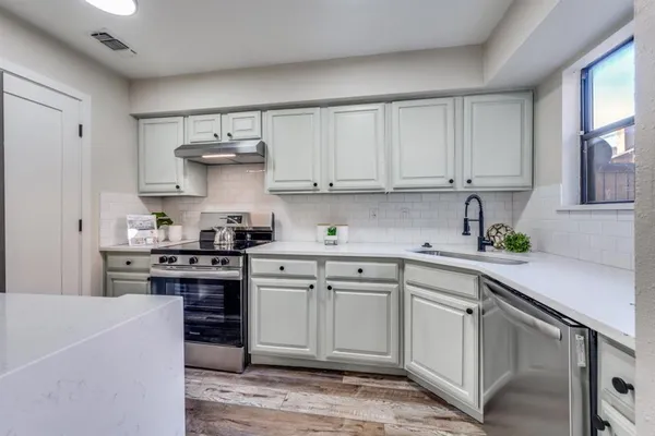 a kitchen with cabinets appliances and a sink
