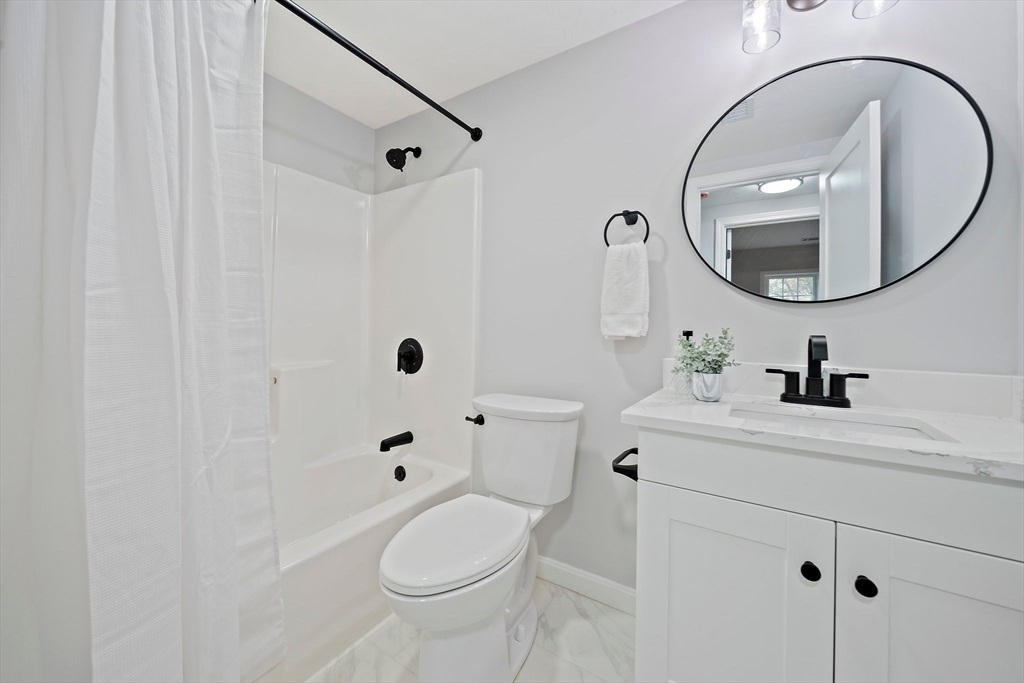 192 Allerton Commons Lane, Unit 192 Braintree, MA 02184 - Photo 14 of 17 a bathroom with a sink a toilet and a mirror