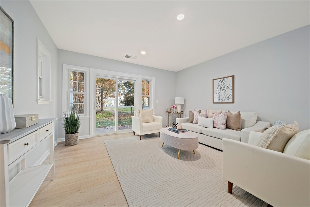 192 Allerton Commons Lane, Unit 192 Braintree, MA 02184 - Photo 2 of 17 a living room with furniture and large windows