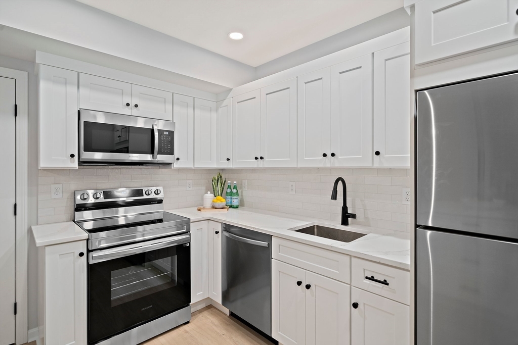 192 Allerton Commons Lane, Unit 192 Braintree, MA 02184 - Photo 4 of 17 a kitchen with appliances a sink and cabinets