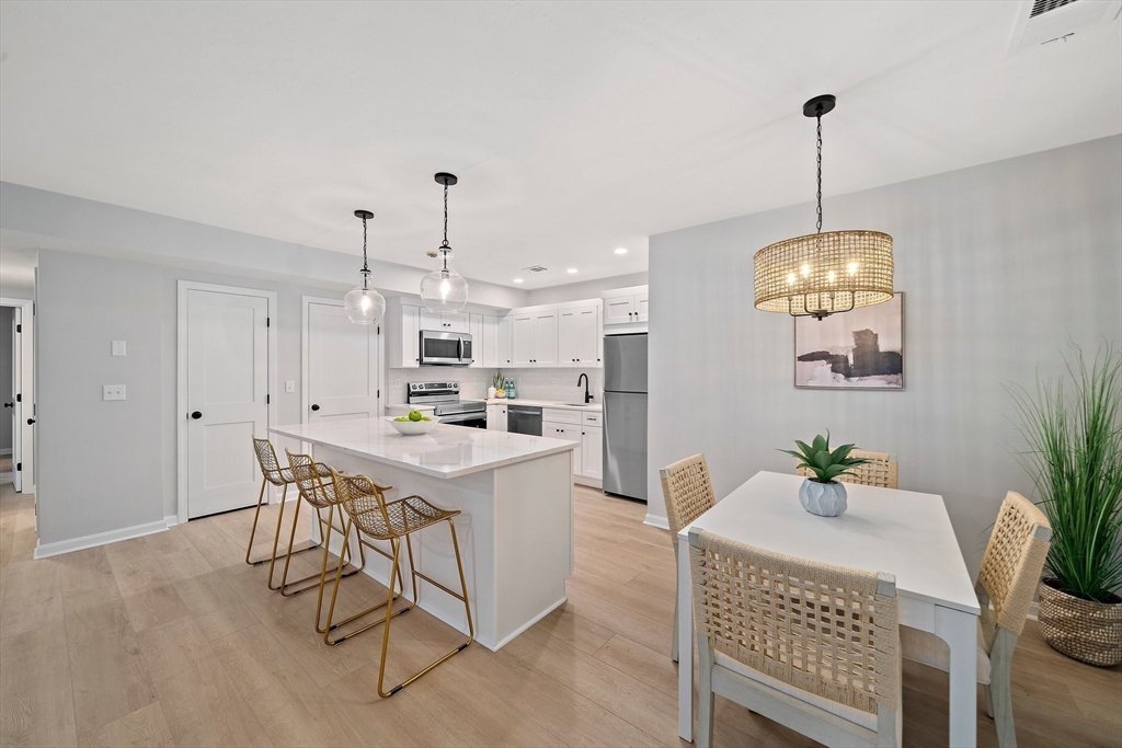 192 Allerton Commons Lane, Unit 192 Braintree, MA 02184 - Photo 5 of 17 a view of a dining room with furniture window and wooden floor