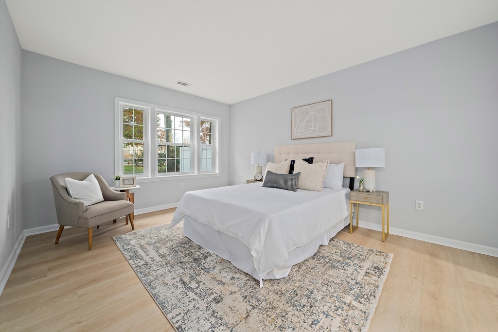 192 Allerton Commons Lane, Unit 192 Braintree, MA 02184 - Photo 10 of 17 a bedroom with a large bed and wooden floor