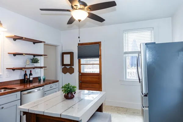 a kitchen with stainless steel appliances a chandelier and refrigerator