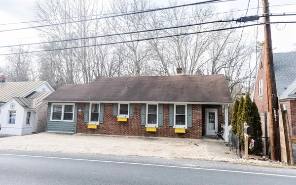 a view of a house with a patio and a yard