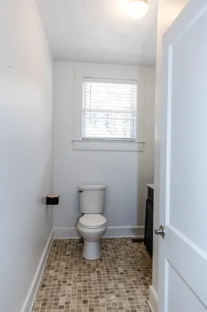 a bathroom with a toilet a sink and a window
