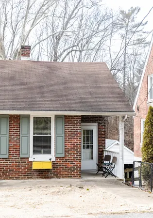 a front view of a house with a tree