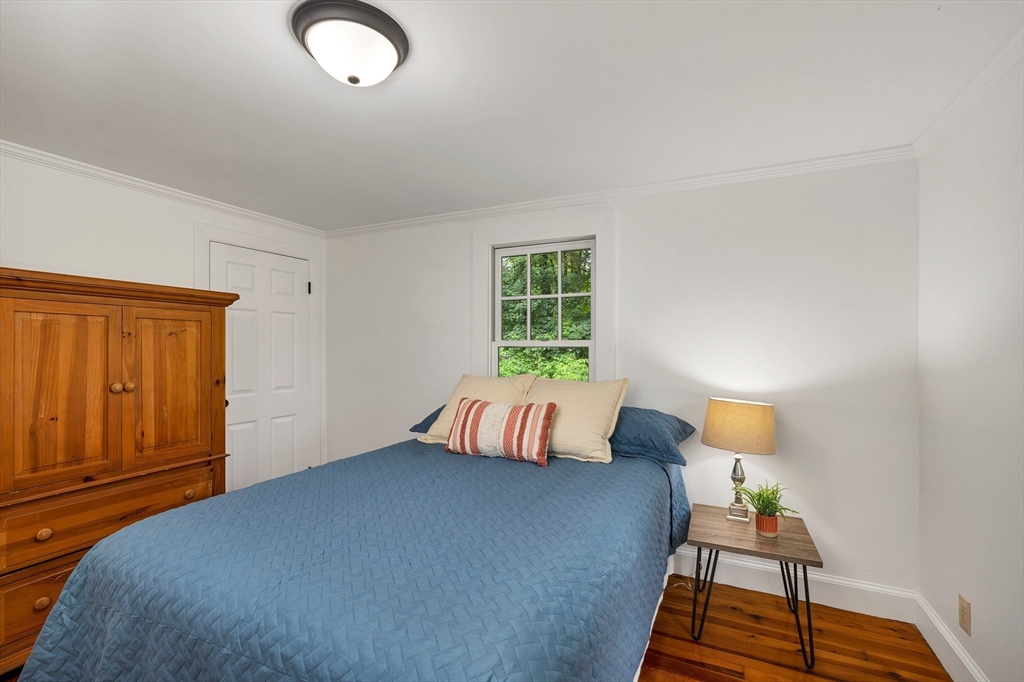 104 Kensington Road Hampton Falls, NH 03844 - Photo 24 of 42 a bedroom with a bed and wooden floor