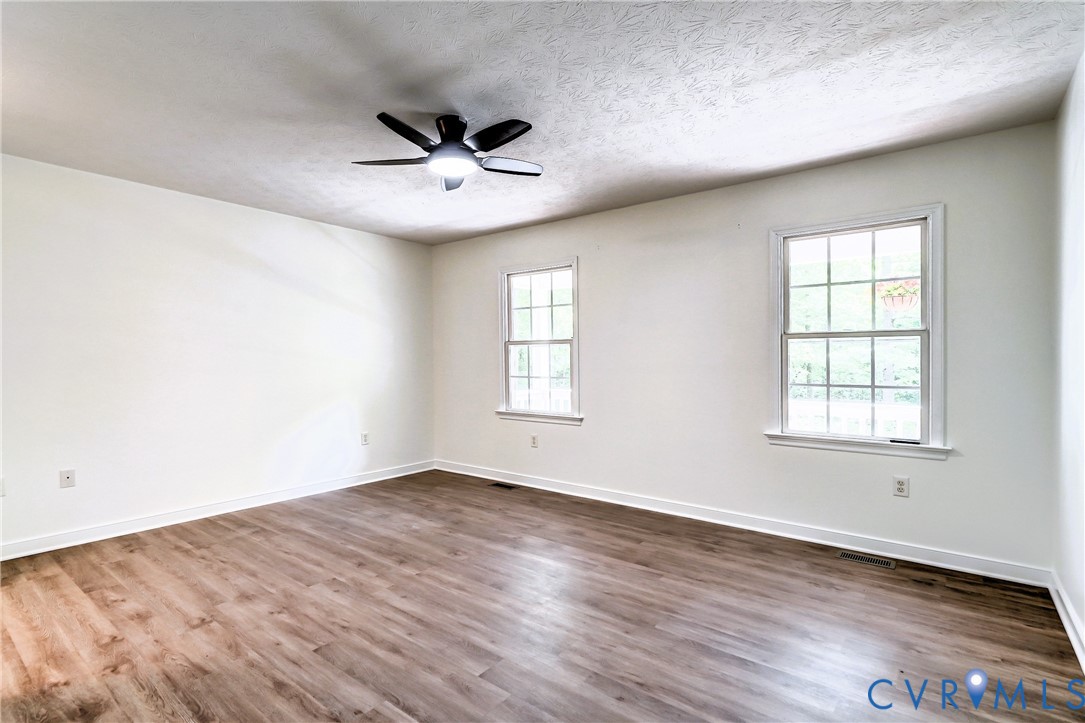 3820 Mt Pleasant Road Providence Forge, VA 23140 - Photo 11 of 40 an empty room with wooden floor ceiling fan and windows
