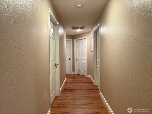 a view of a hallway with wooden floor