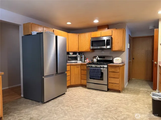 a kitchen with stainless steel appliances a refrigerator stove and microwave