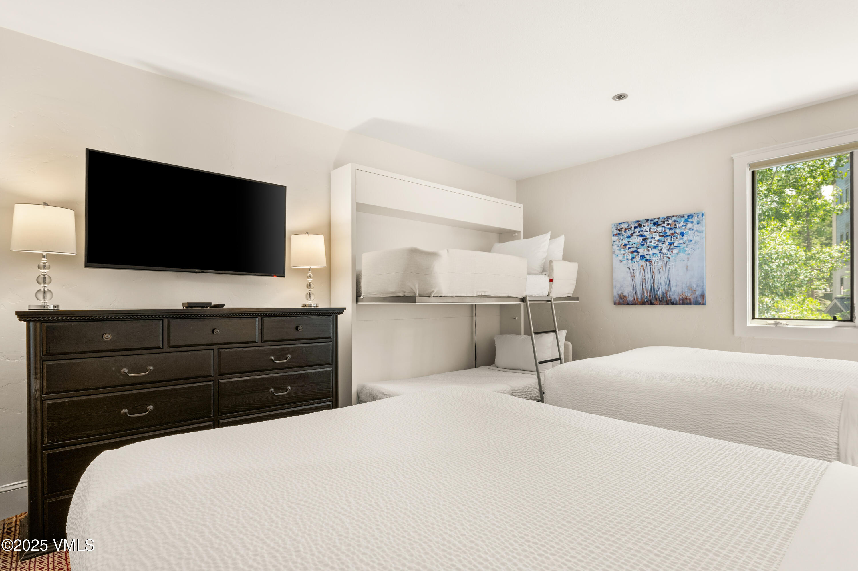 311 Offerson Road, Unit 223 Beaver Creek, CO 81620 - Photo 19 of 37 a bedroom with a bed and a flat screen tv