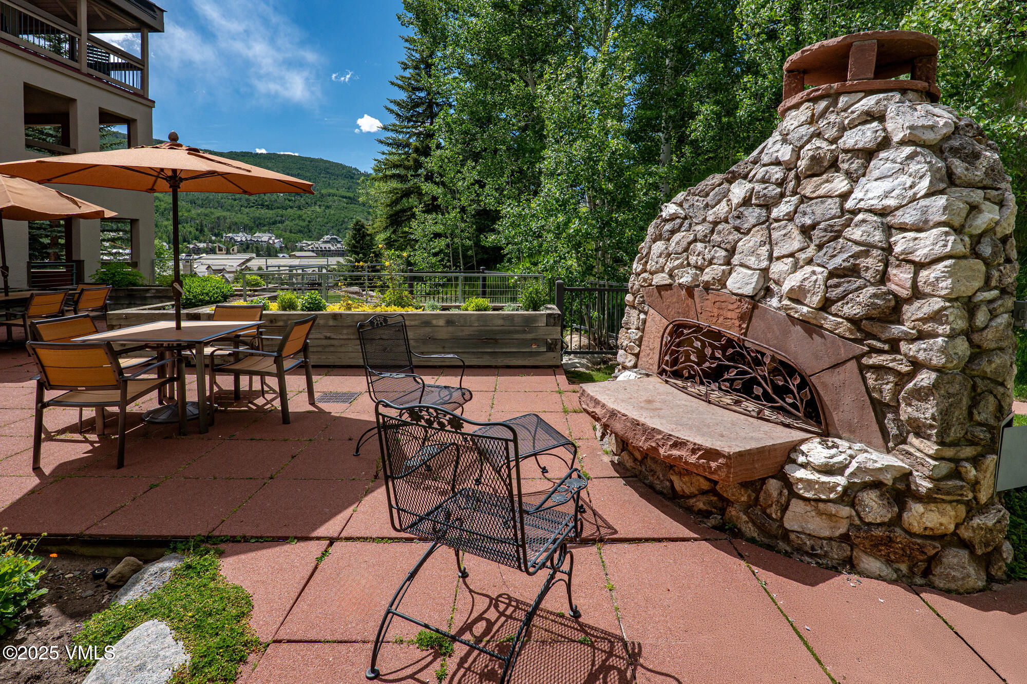311 Offerson Road, Unit 223 Beaver Creek, CO 81620 - Photo 30 of 37 a view of a patio with table and chairs under an umbrella with a barbeque