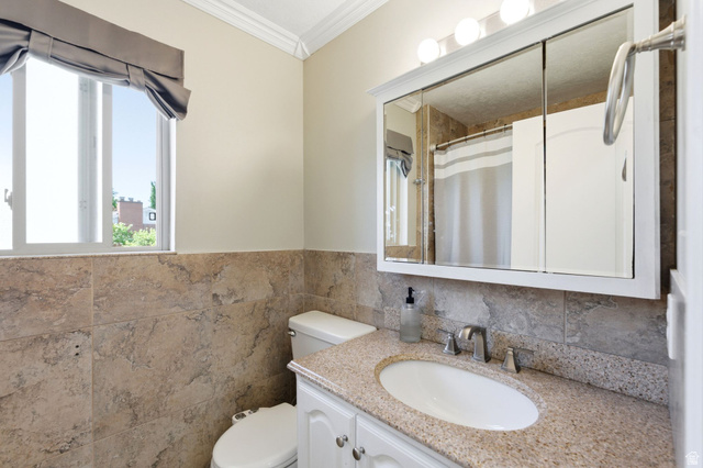 935 900 North Bountiful, UT 84010 - Photo 18 of 46 Bathroom with vanity, ornamental molding, a shower with curtain, a wainscoted wall, and tile walls