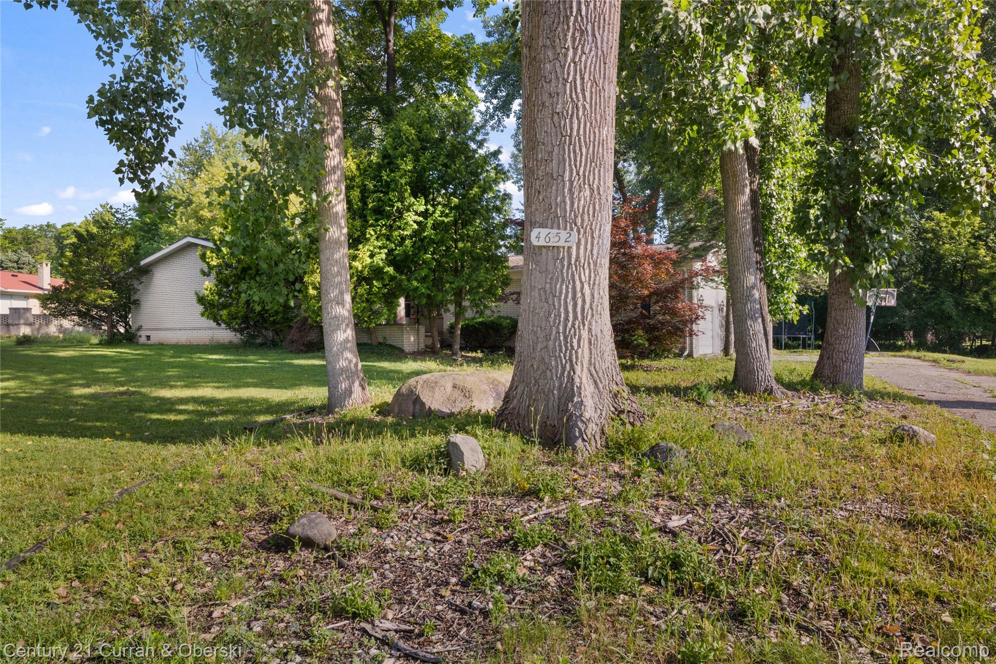 4652 Patrick Road West Bloomfield, MI 48322 - Photo 21 of 27 Mature trees framing the property entrance, with visible house number