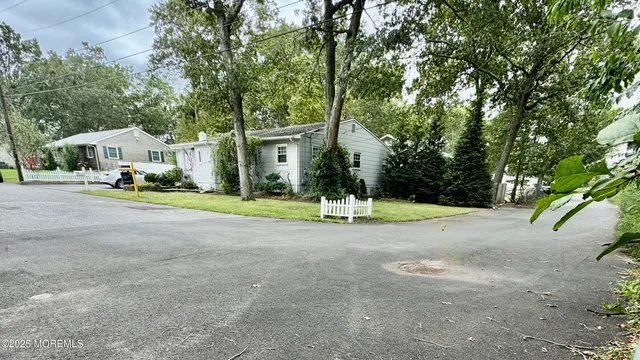 a view of a house with a big yard and large trees