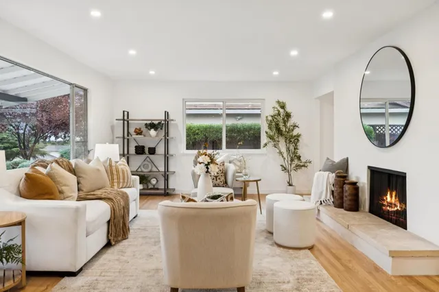 a living room with furniture a clock and a table