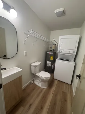 a white toilet sitting next to a bathroom sink and a mirror