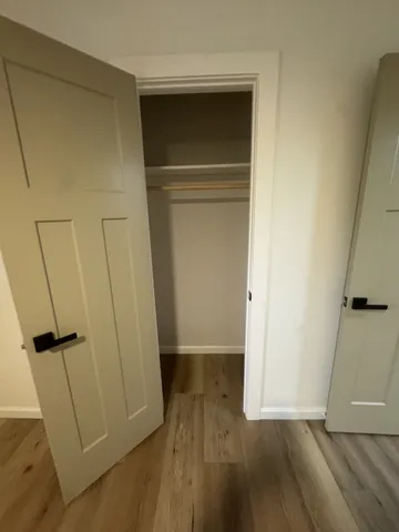 a view of empty room with wooden floor