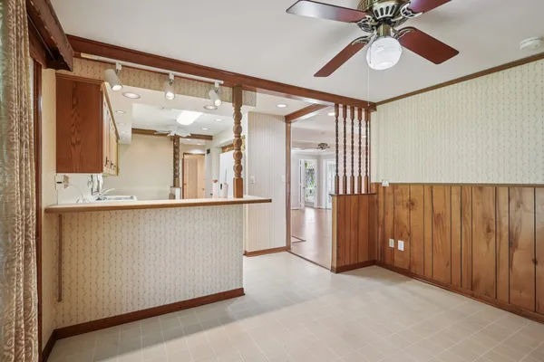 a view of a hallway with a chandelier fan and windows