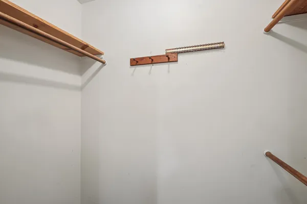 an empty room with windows & a ceiling fan