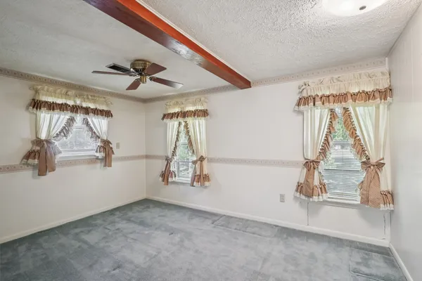 a view of a livingroom with a ceiling fan and window
