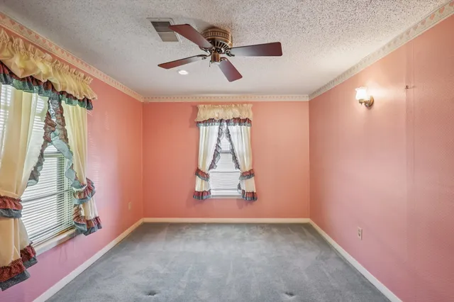 a view of a livingroom with a ceiling fan and window