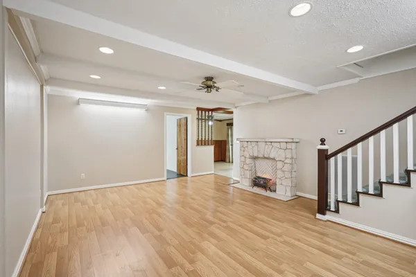 a view of a livingroom with wooden floor and a ceiling fan