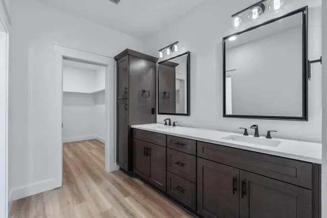 a view of a big room with wooden floor a ceiling fan and windows