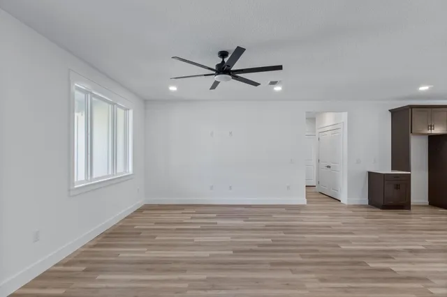 a view of a livingroom with a ceiling fan hardwood floor and a ceiling fan