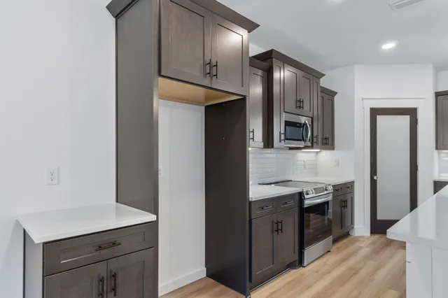 a kitchen with stainless steel appliances granite countertop a sink a stove and a refrigerator