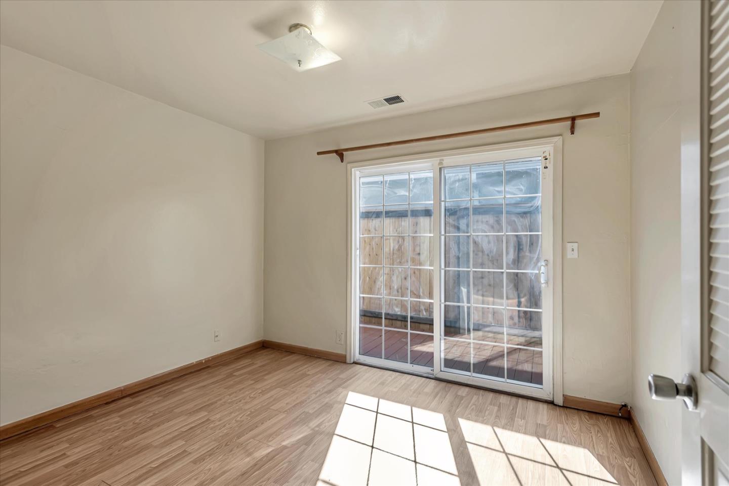 675 Crespi Drive Pacifica, CA 94044 - Photo 26 of 55 an empty room with wooden floor and windows
