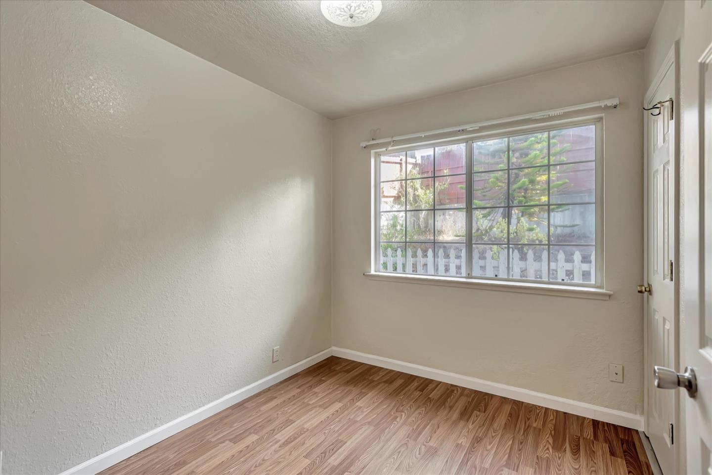 675 Crespi Drive Pacifica, CA 94044 - Photo 36 of 55 an empty room with wooden floor and windows