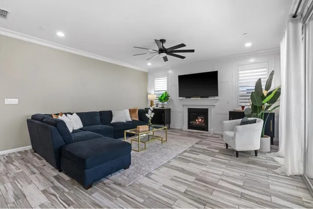a living room with furniture a flat screen tv and a fireplace