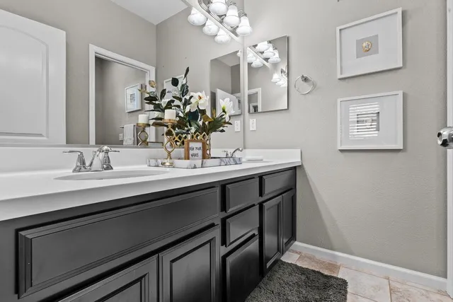 a bathroom with a sink a light fixture and a mirror