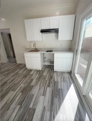 a view of kitchen with wooden floor and electronic appliances