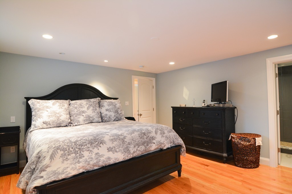 15 Melvin Road Arlington, MA 02474 - Photo 12 of 26 a bedroom with a large bed and a flat screen tv