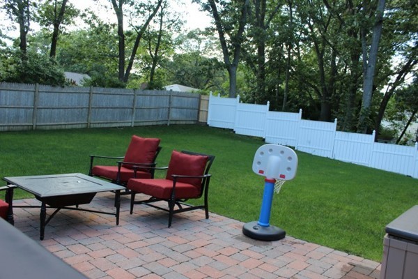 15 Melvin Road Arlington, MA 02474 - Photo 25 of 26 a view of a backyard with chairs potted plants and a tree