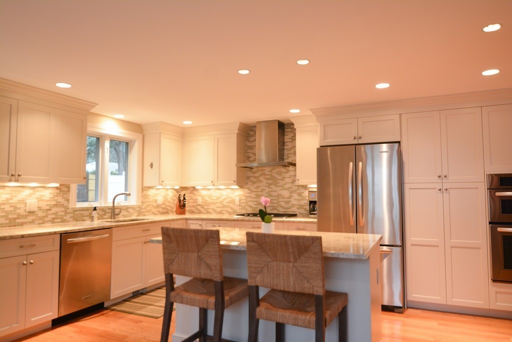 15 Melvin Road Arlington, MA 02474 - Photo 7 of 26 a kitchen with stainless steel appliances granite countertop a refrigerator a sink a stove a dining table and chairs