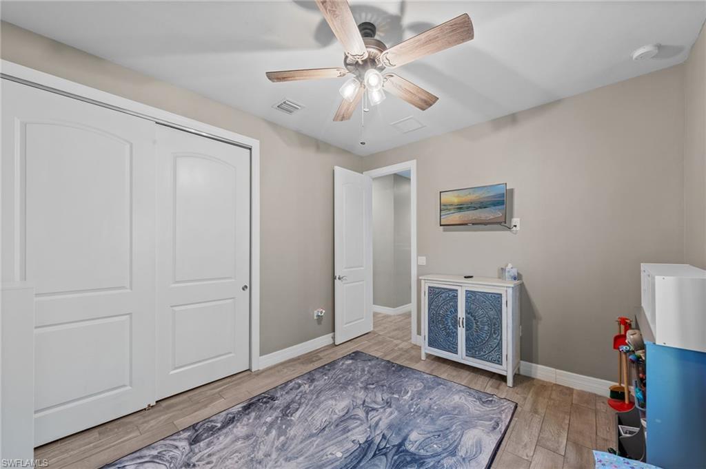 4914 Seton Way Immokalee, FL 34142 - Photo 22 of 46 Bedroom featuring ceiling fan, light wood-style flooring, and a closet